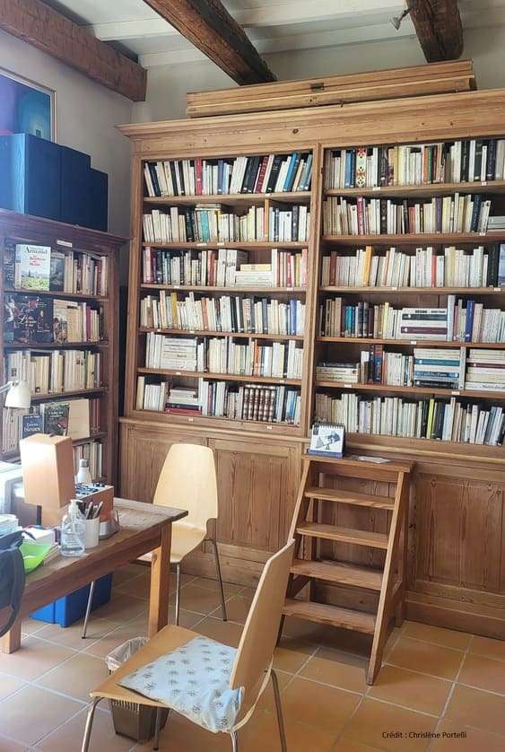 Espace adultes de la bibliothèque de Saint-Hilaire d’Ozilhan avec grandes étagères de livres